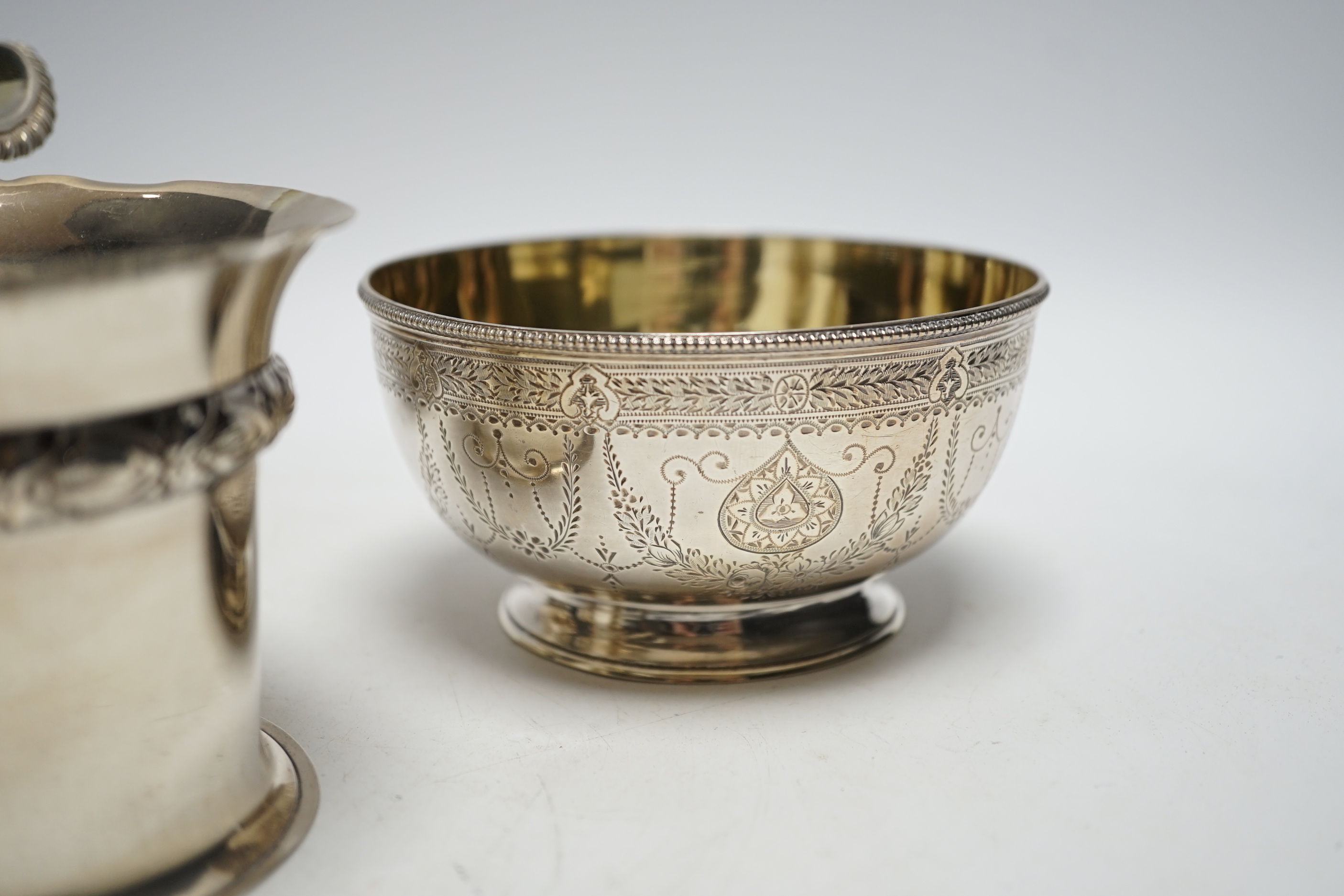 Two silver sugar bowls, London, 1877 and London, 1904, the latter with ring handles, diameter 10.8cm, a silver small vase and a George IV silver cream jug, 21.9oz.